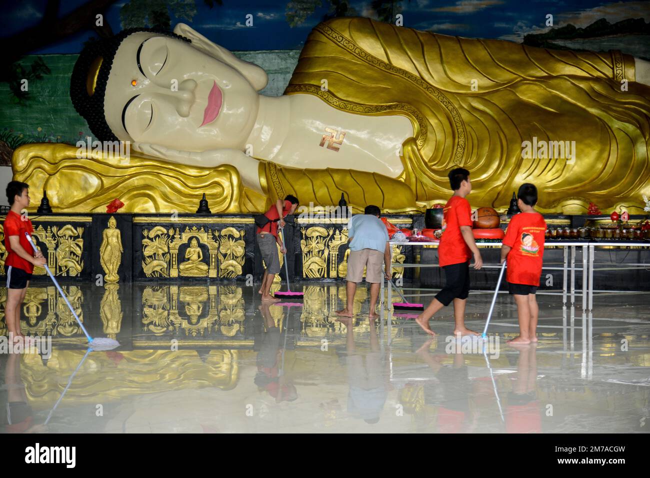 Devotees clean a statue of Buddha at a temple in Bogor, West Java ...