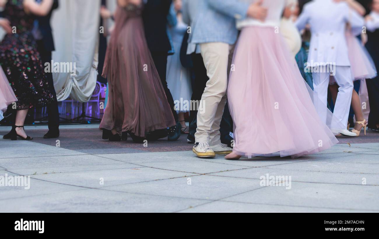 High school graduates dancing waltz and classical ball dance in dresses