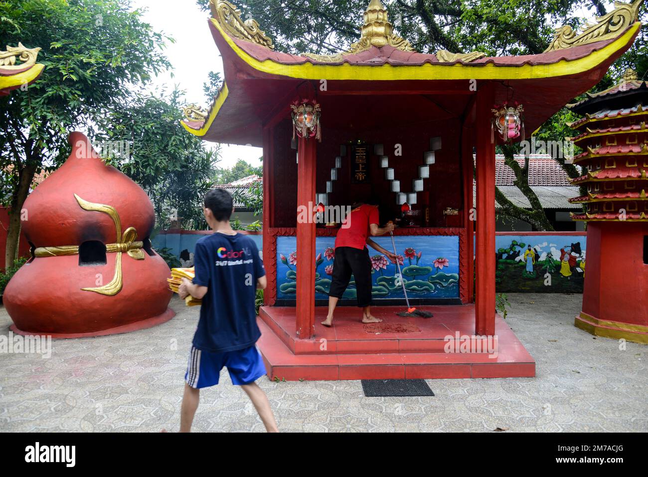 A devotees cleans the floor at a temple in Bogor, West Java, Indonesia ...