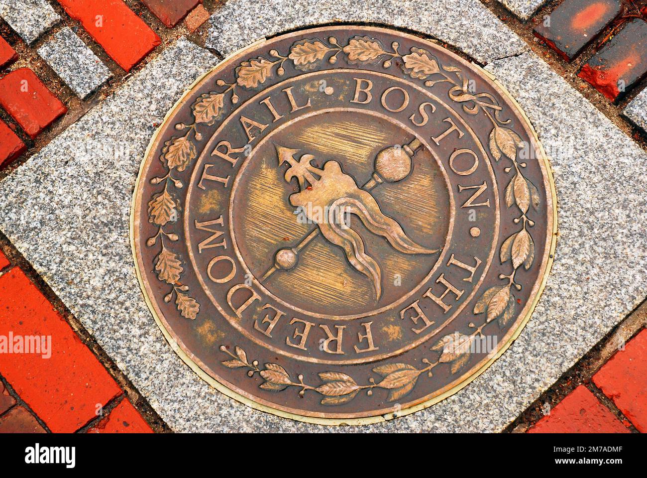 A circular marker on the sidewalk notes the Freedom Trail, a path that connects the historic sites of Boston Stock Photo