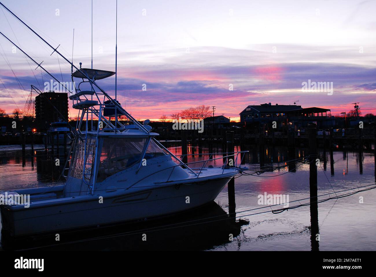 A winter sunset glows and the few remaining recreation boats in a calm