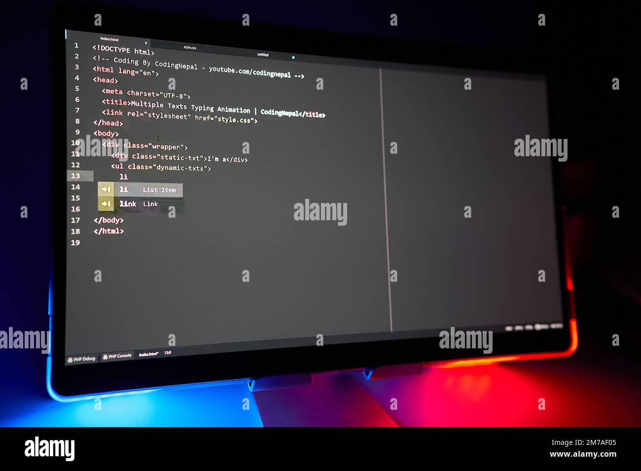 Writing computer code displayed on monitor neon blue and red lights ...