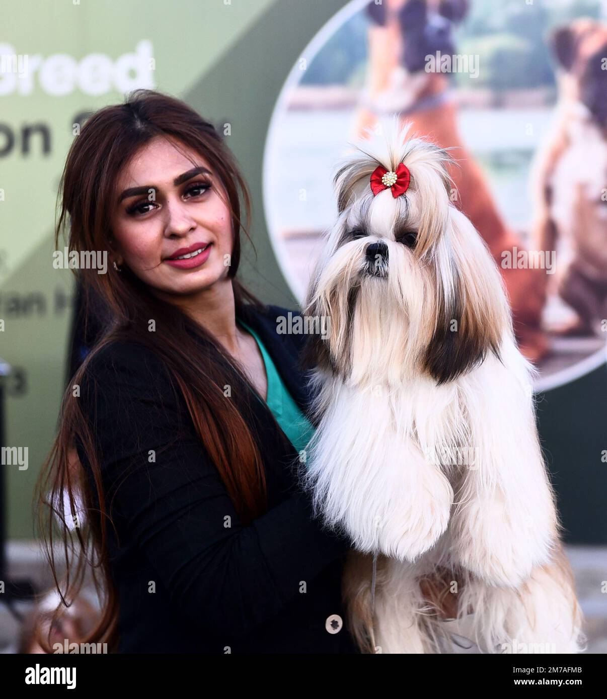 Karachi. 8th Jan, 2023. A woman poses for a photo with her dog during a
