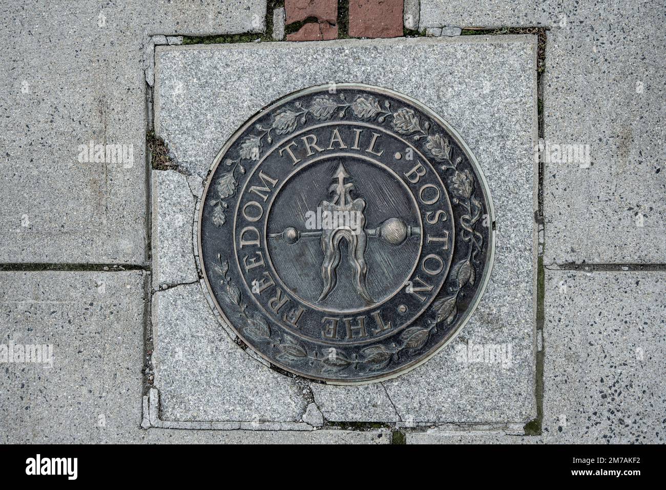 sidewalk emblem of the Boston Freedom Trail pointing in the direction of the walking trail used by historians and tourists Stock Photo