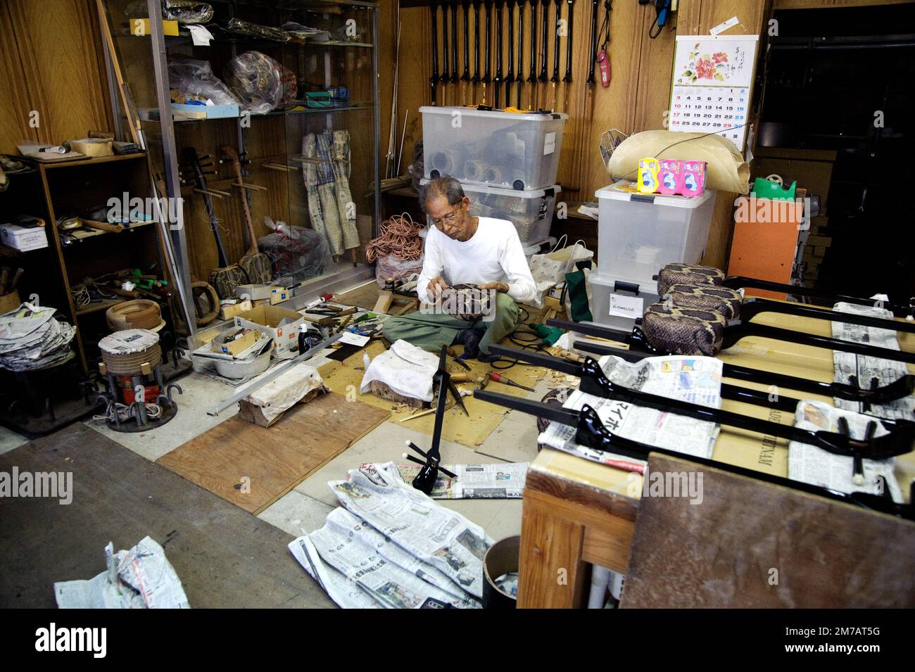 A craftsman putting the finishing touches on a batch of 'sanshin' instruments. I noticed the scene and asked if I could step in for some photos. Stock Photo