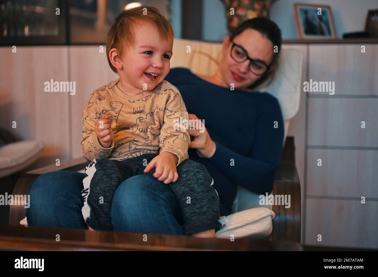 Pregnant mother holding her little toddler in a lap Stock Photo