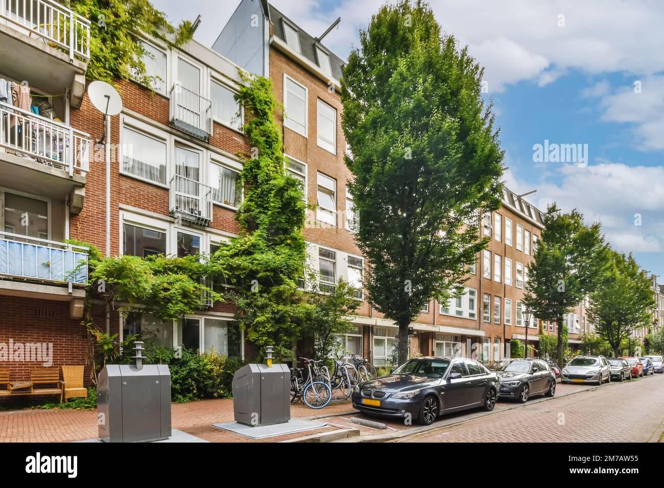 an apartment complex in the netherlands, with cars parked on the street