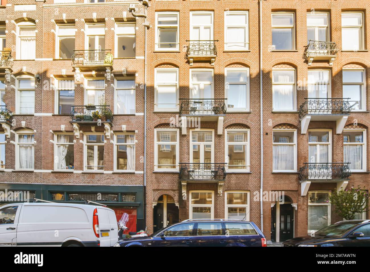 an apartment building with cars parked on the street next to it and ...