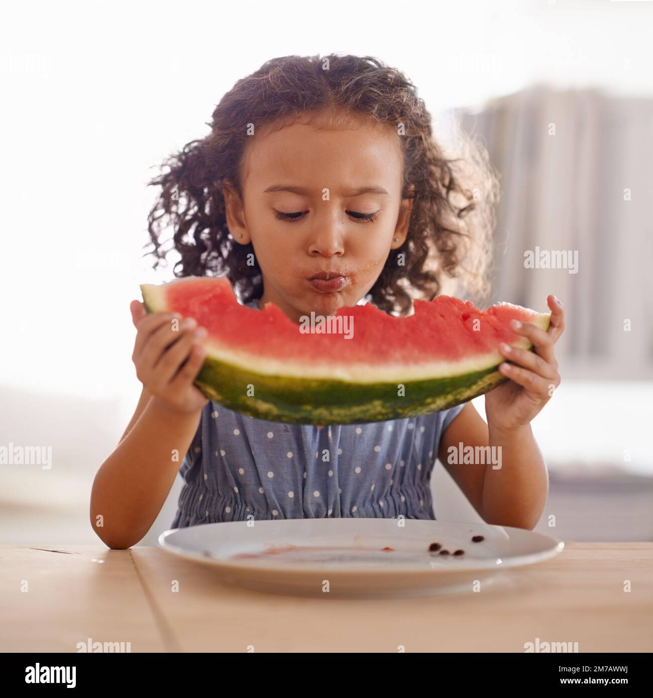 This is bigger than me. a cute little girl eating watermelon Stock