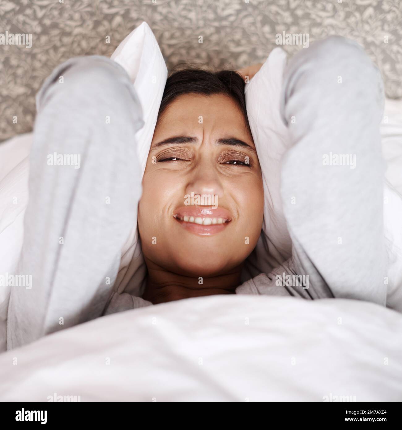 What is making that noise. A young woman looking frustrated in bed