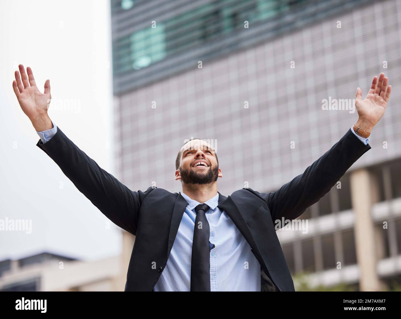 Businessman celebration, city and winning with smile, success or suit in financial advisor job. Corporate man, hands and air goals, vision or Stock Photo