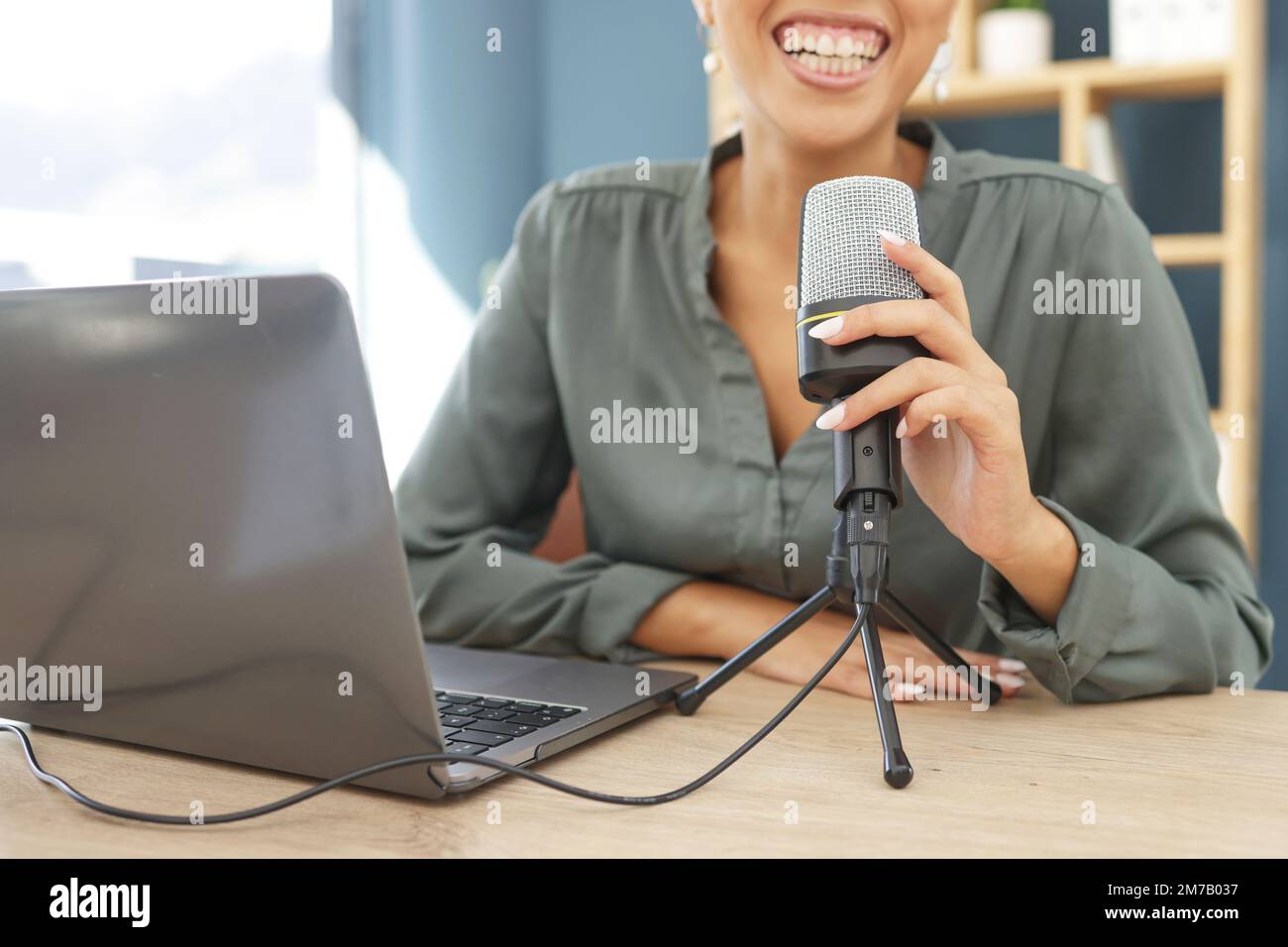 Laptop, podcast microphone and black woman live streaming business tips in home office. Influencer, broadcast and hand of female podcaster, radio host Stock Photo