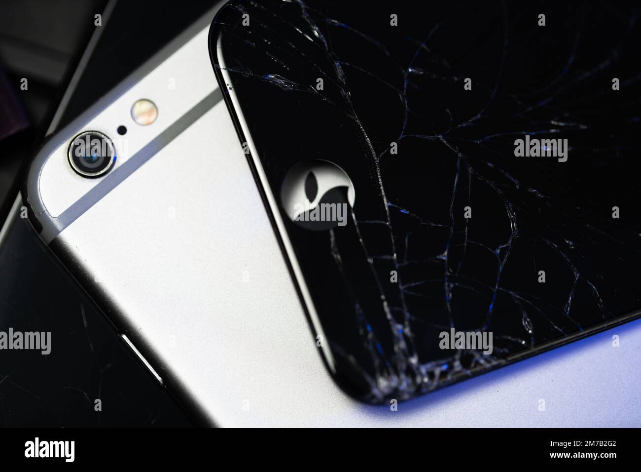 South Tyrol, Italy - Jan. 7. 2023: Apple iPhone 6 and broken display on top. Repairing Apple devices. Apple Logo Stock Photo