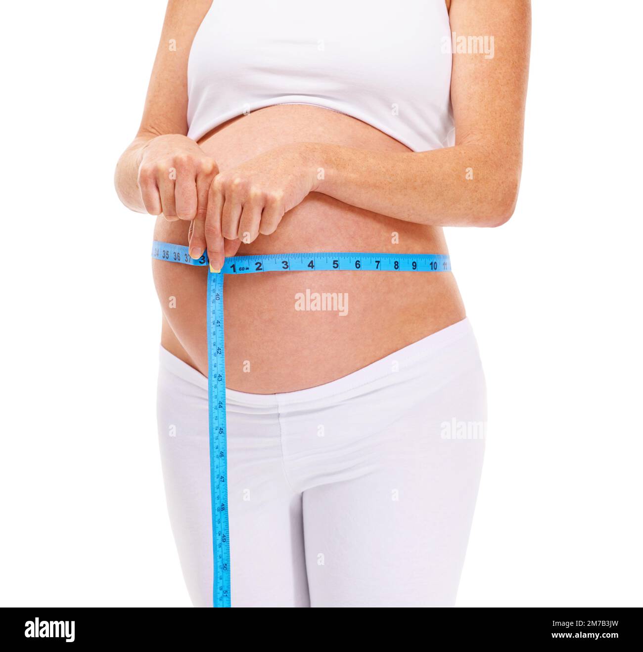 This little guy is growing. An expectant mother measuring her belly. Stock Photo