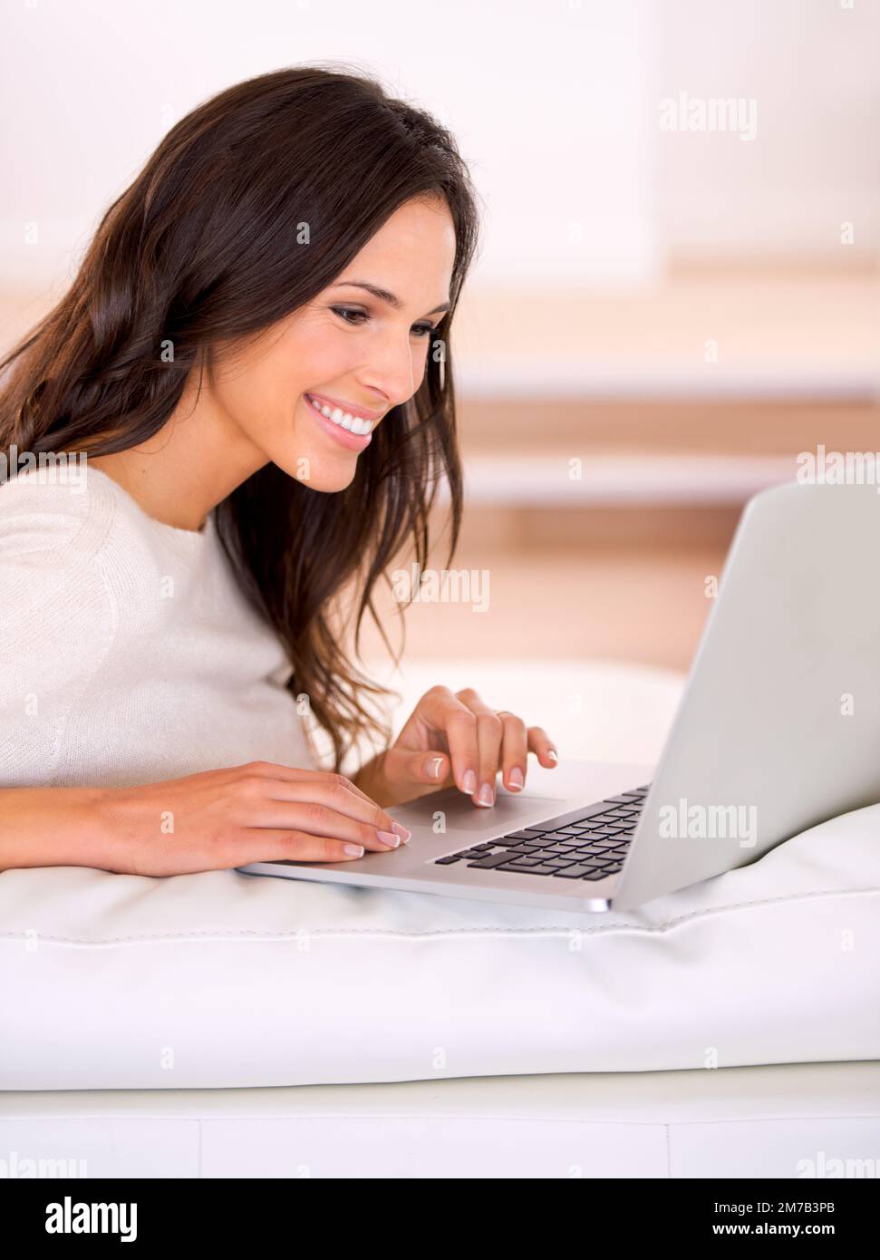 Keeping my blog up to date. a gorgeous young woman on a couch. Stock Photo