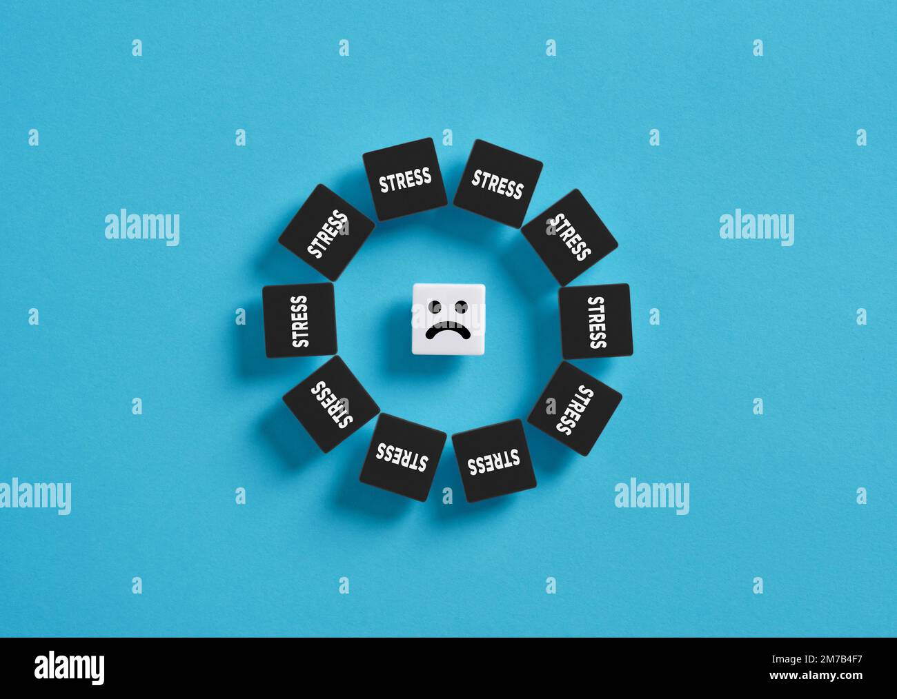 Stress, anxiety and depression problem. Work tension and unhappiness. Unhappy emoticon surrounded with black blocks with the word stress. Stock Photo