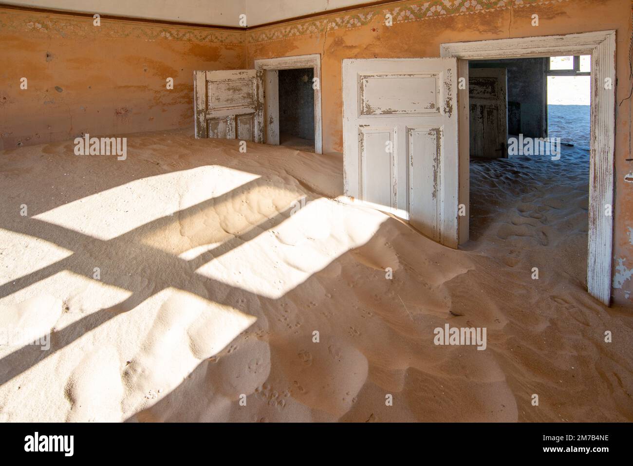 abandoned house interior full of sand in  Kolmanskop town in Namibia Stock Photo