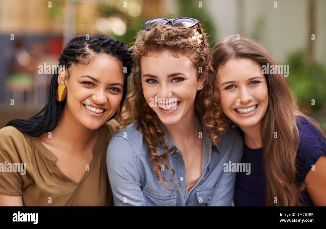Friends are the family we choose for ourselves. A portrait of three natural beauties sitting outdoors enjoying the sunlight. Stock Photo