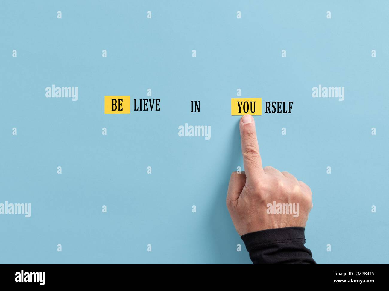 Motivational inspirational concept. Self confidence, determination and self motivation. Male hand transforms Believe in yourself sign into be you mess Stock Photo