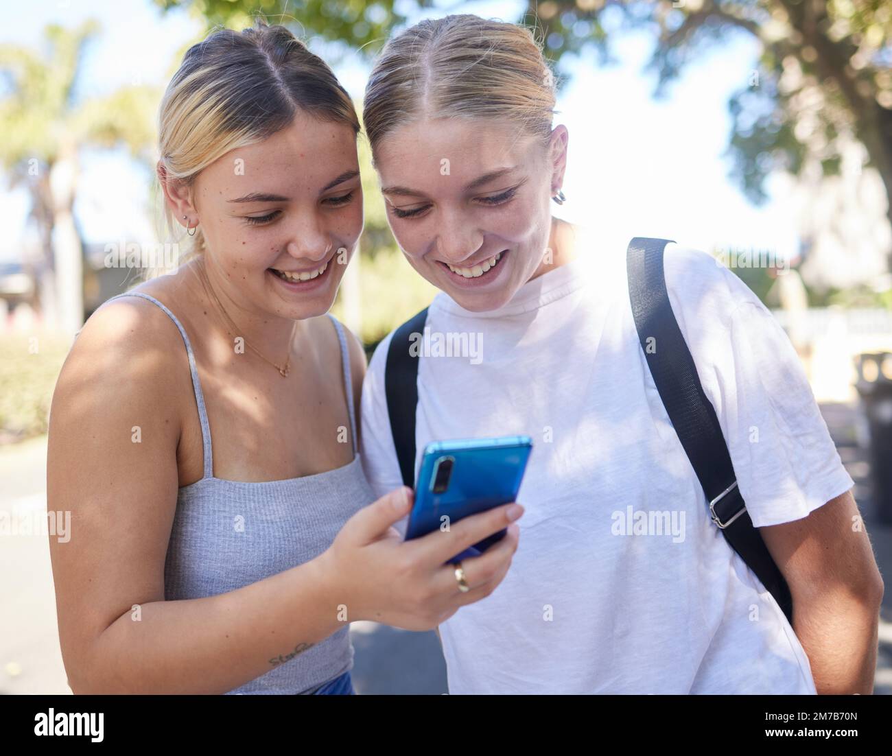 Smartphone, park and student friends on internet, social media post or website information search for university, campus or college. Youth women Stock Photo