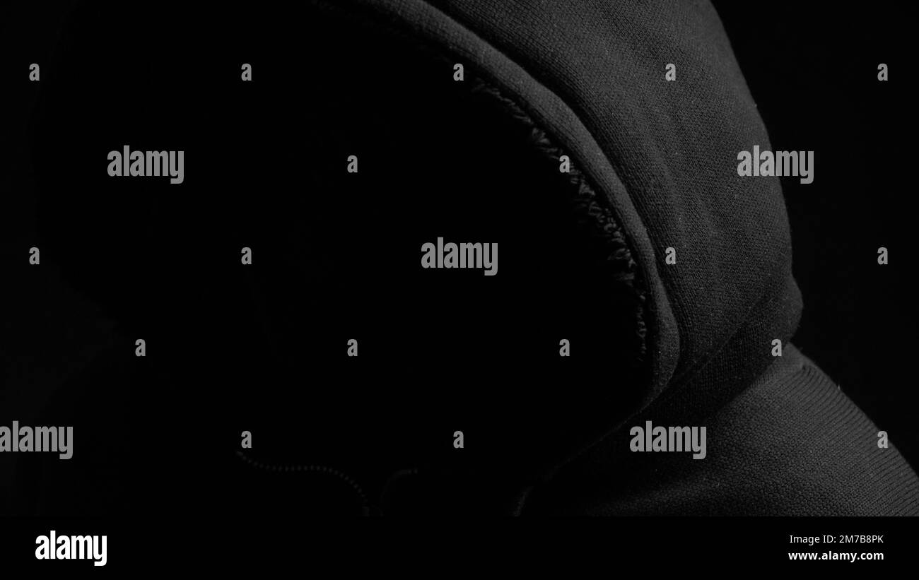 Silhouette in casual sportswear with hood. Faceless unrecognizable man