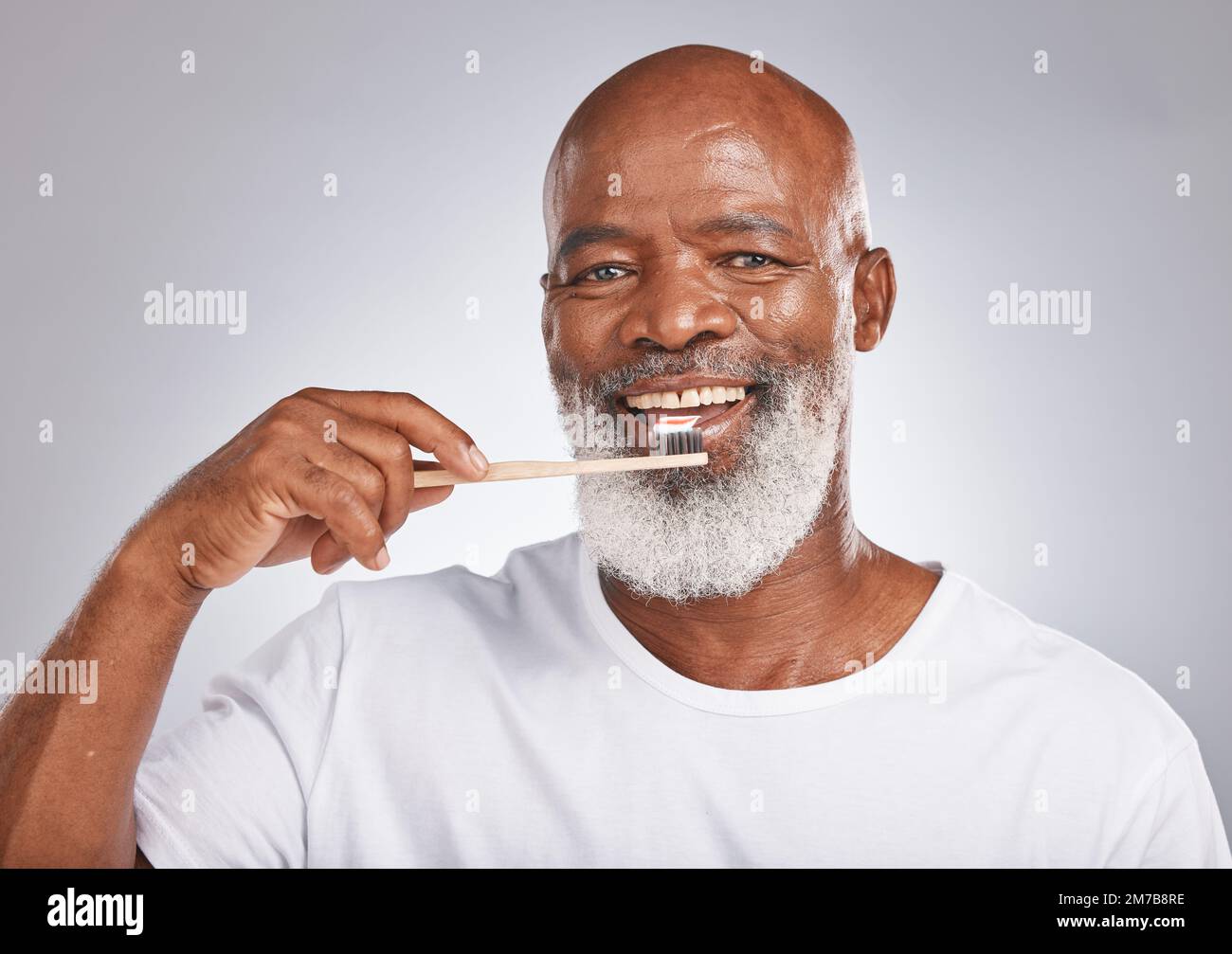 Brushing teeth, studio portrait and black man with toothbrush for mature dental wellness, healthy lifestyle or cleaning aesthetic in Nigeria. Happy Stock Photo