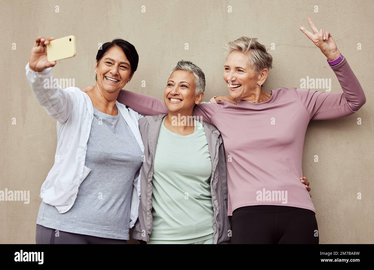 Phone selfie, senior women and peace sign fitness for exercise training, workout motivation or happy sports lifestyle. Elderly friends, smile and Stock Photo