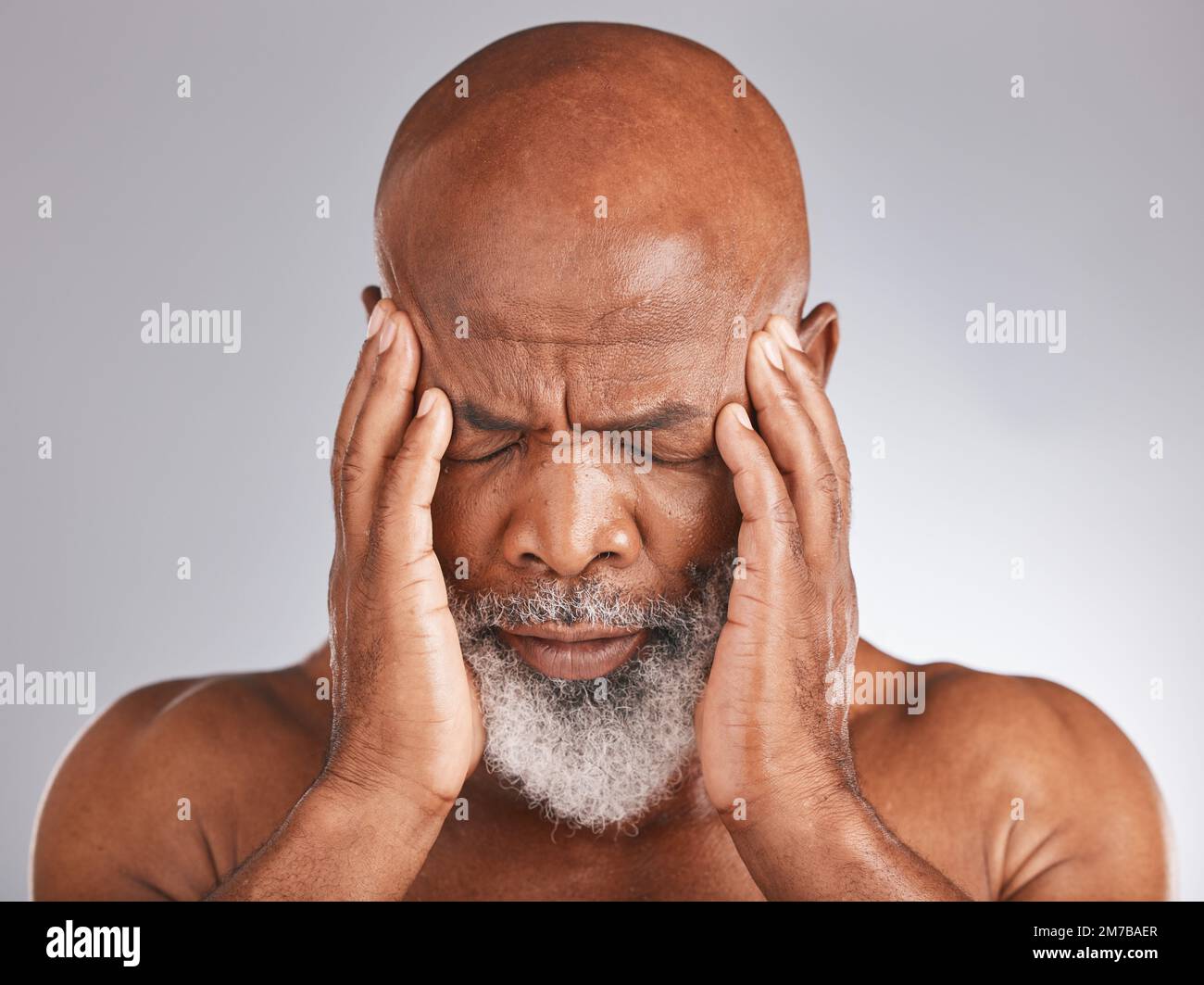 Elderly black man, headache and pain with hands and face, stress and mental health against studio background. Depression, skin and senior with Stock Photo