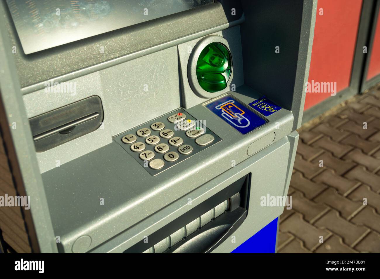View and closeup of an ATM with a keyboard in English and Polish