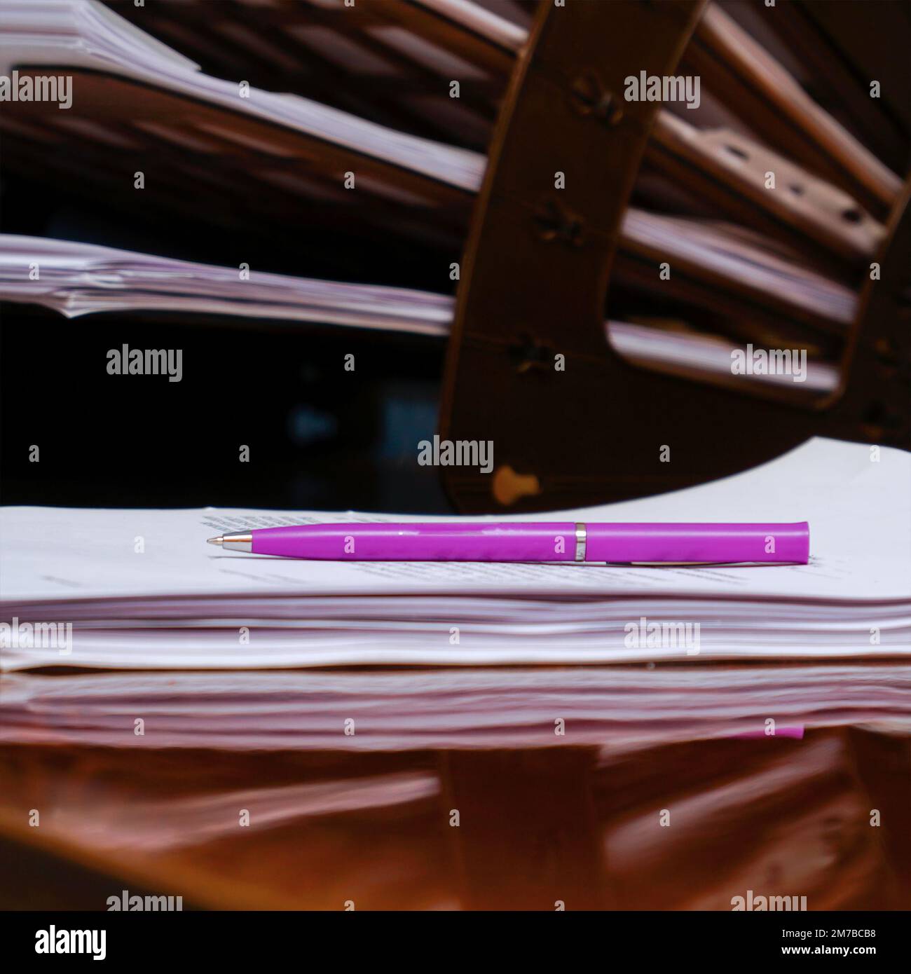 Plastic organizer for documents on the office desk. The pink pen lies on business papers, documents Stock Photo