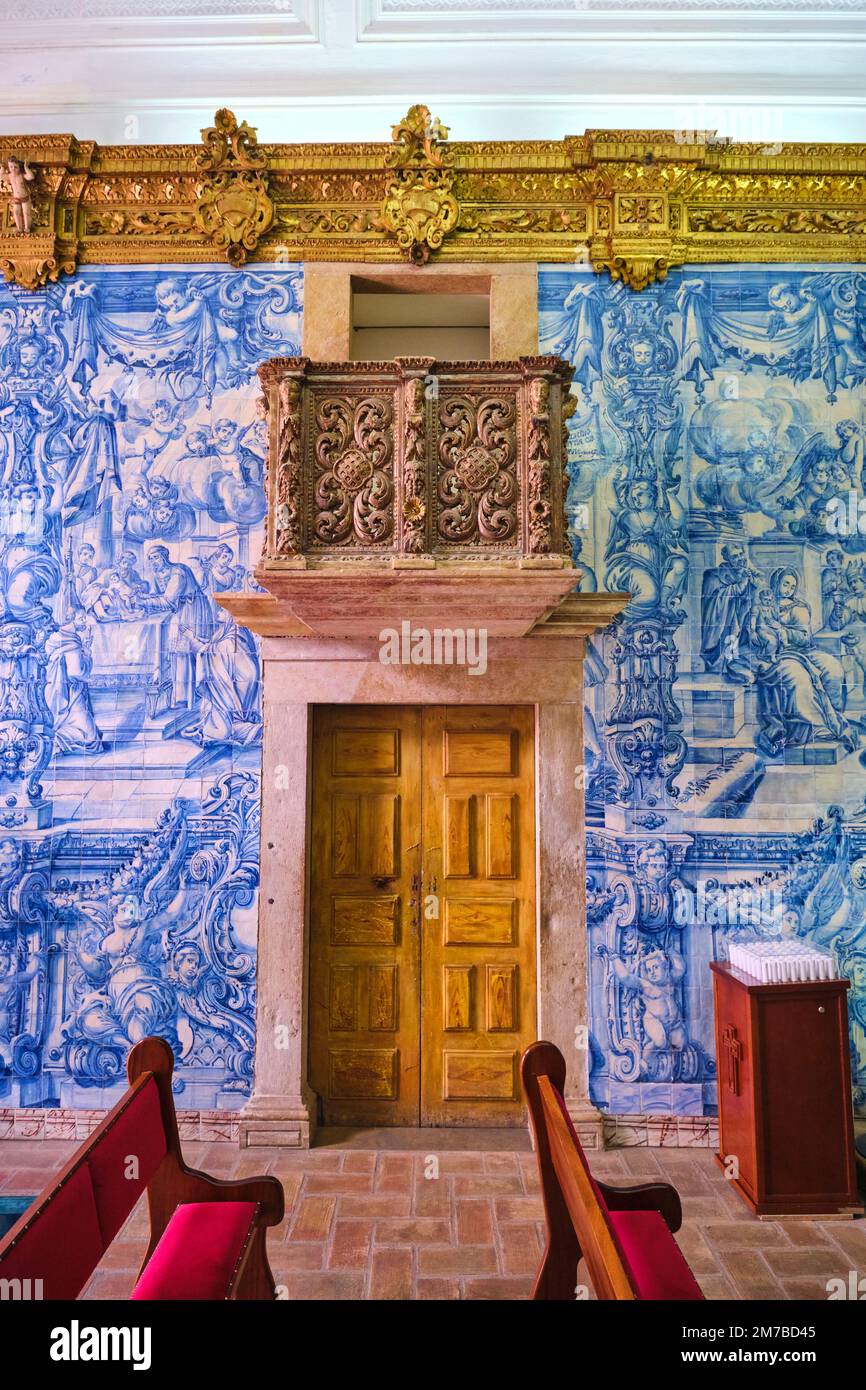 A side door and balcony, surrounded by gold carving work and Azulejo, blue tile walls. At the Ermida de Nossa Senhora da Conceição Catholic church, ch Stock Photo