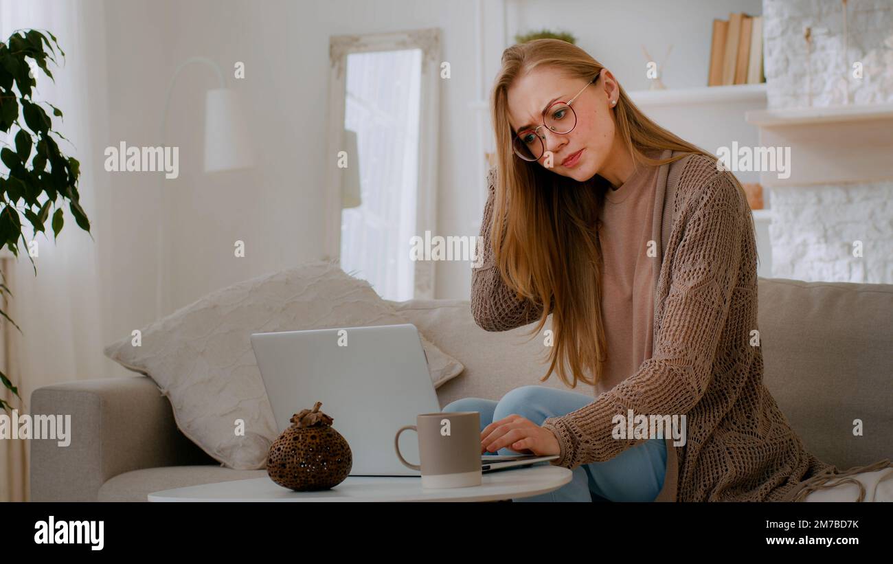 Caucasian woman confused girl with broken laptop worry angry about bad WI-FI Internet connection annoy lady in eyeglasses annoyed with online account Stock Photo