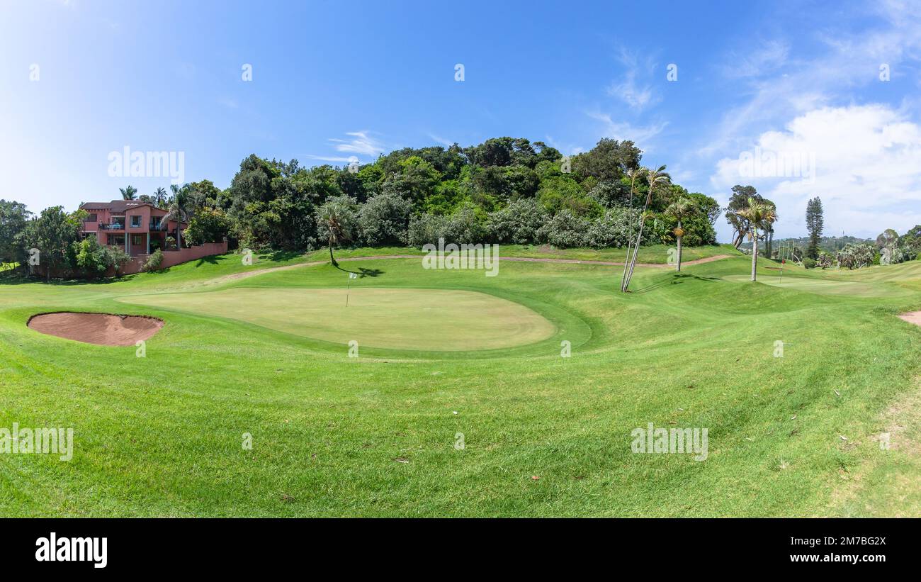 Golf Course scenic layout of coastal design two holes putting greens surrounded by green  trees vegetation summer blue sky landscape. Stock Photo