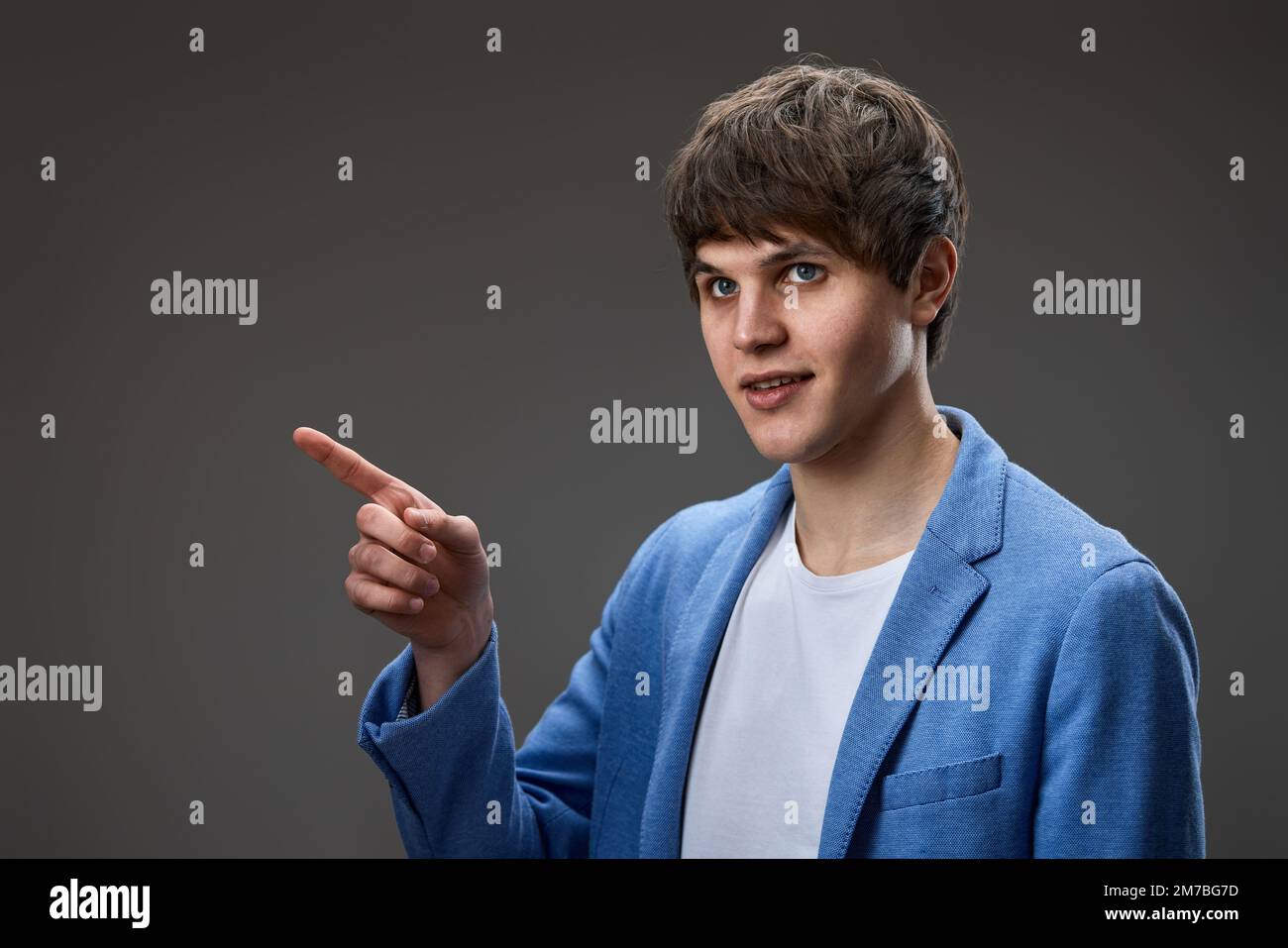 young man in jacket pointing at copy space Stock Photo