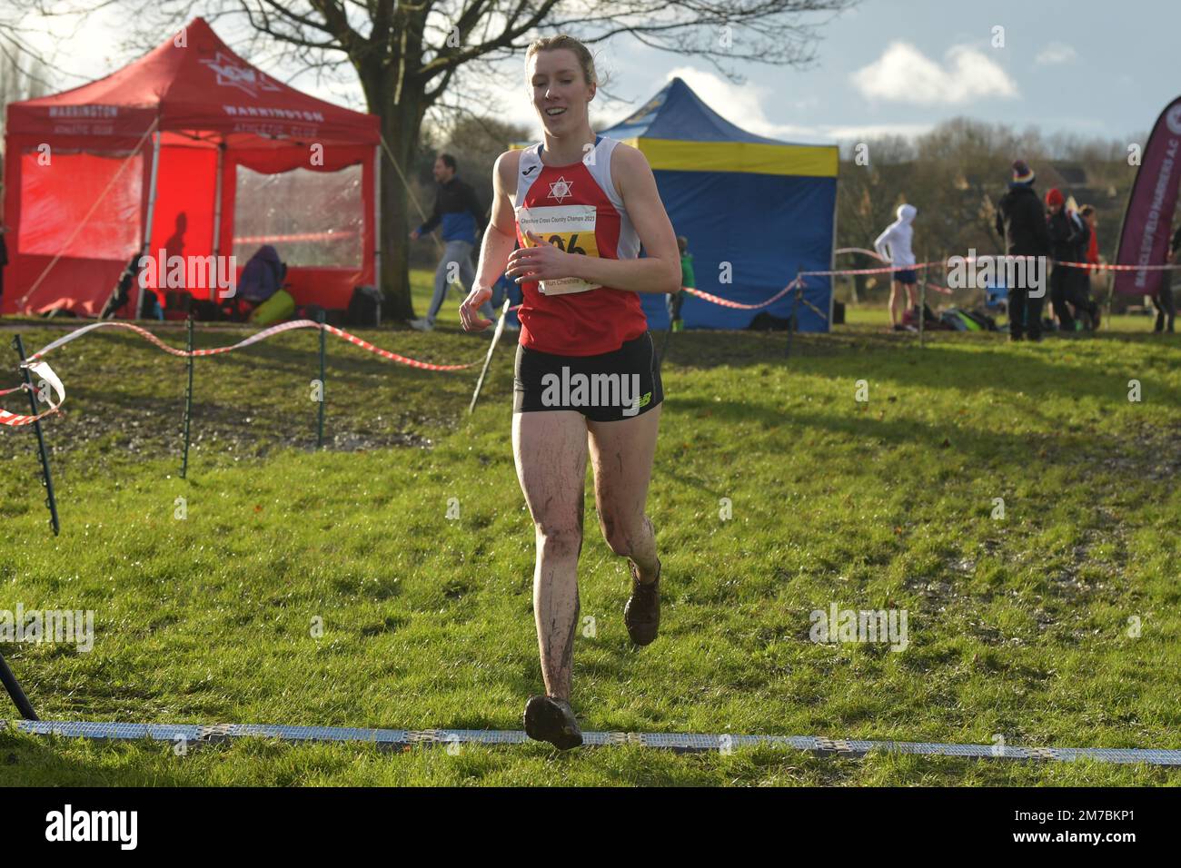 Winsford, UK. Sunday, 8 January 2022. The colder, 7 °C, start of the day. After torrential rain in the morning, sky clears up. Some sunshine, partly cloudy. Harriet Knowles-Jones, Warrington athletics club wins Cheshire County AA 2023 Annual Cross Country Championships, senior/veteran female and u20 female category. The crowds are excited to see her return to cross country. Knights Grange, Winsford, UK. © Yoko Shelley Credit: Yoko Shelley/Alamy Live News Stock Photo