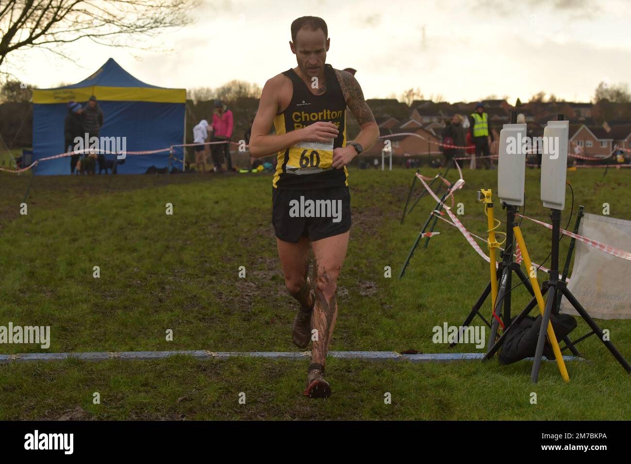 Winsford, UK. Sunday, 8 January 2022. The colder, 7 °C, start of the day. After torrential rain in the morning, sky clears up. Windy and partly cloudy. Gavin Tomlinson, Chorlton Runners, wins Cheshire County AA 2023 Annual Cross Country Championships, senior/veteran male and u20 male category. Knights Grange, Winsford, UK. © Yoko Shelley Credit: Yoko Shelley/Alamy Live News Stock Photo
