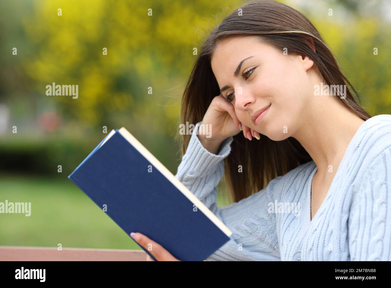 Teen reading a paper book in a park Stock Photo
