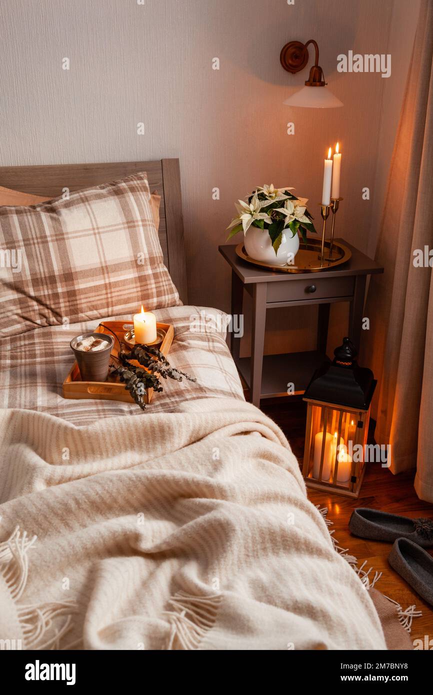 cozy scandinavian bedroom interior in natural tones, blanket lantern