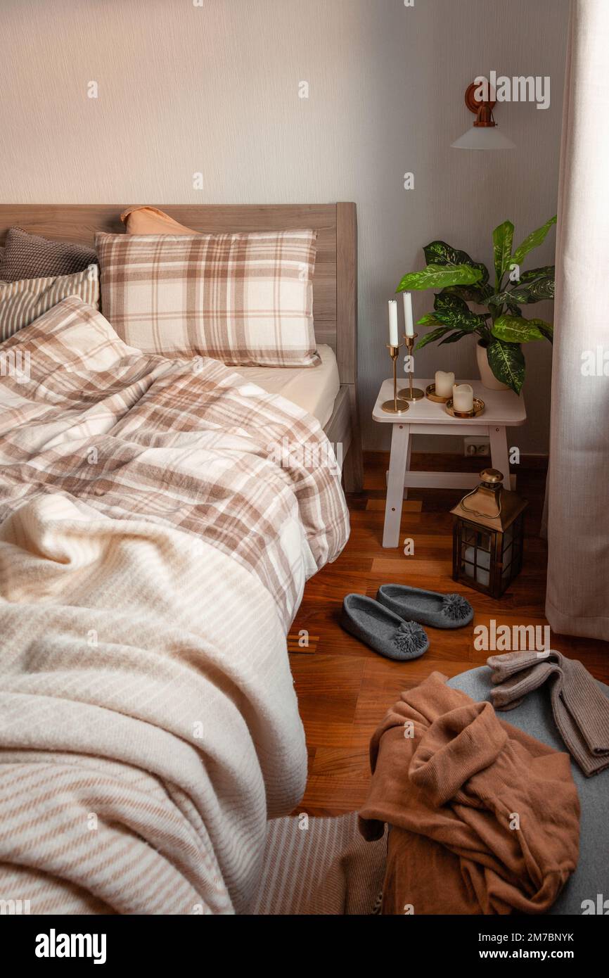 cozy scandinavian bedroom interior in natural tones, real life mess disorder Stock Photo