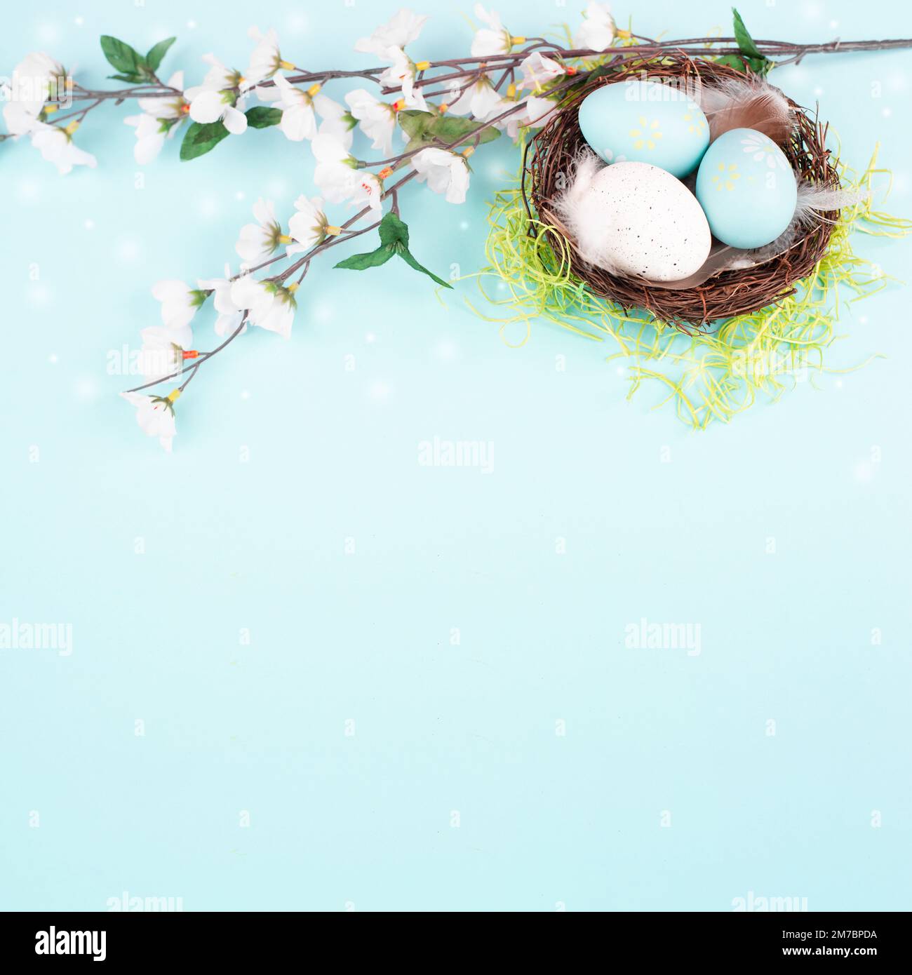 Colored easter eggs in a bird nest, pink cherry blossoms, green grass ...