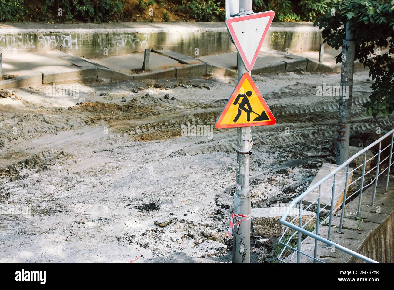 Sign Ripped Off Repair work on city street. A triangle-shaped sign with a pictograph ...