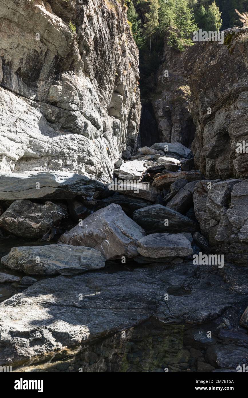 Bed of Lillaz waterfall (Cascate di Lillaz) divided by thousands of years of formation in granite alpine rocks, dried up this season with little pond. Stock Photo