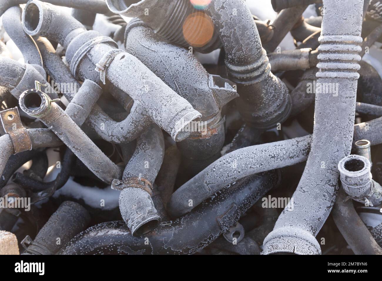 Old rubber hoses that pile together many lines. The tubes are piled up in a warehouse of an enterprise that disassembles old cars for spare parts for Stock Photo