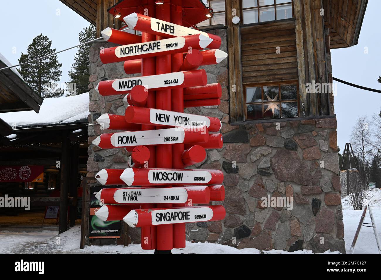 Some kilimeters north of Rovaniemi, the Santa Claus village displays an original international sign board listing the main world cities. Stock Photo