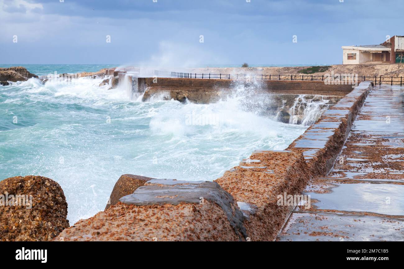 Coastal landscape with stone fortifications and breaking waves
