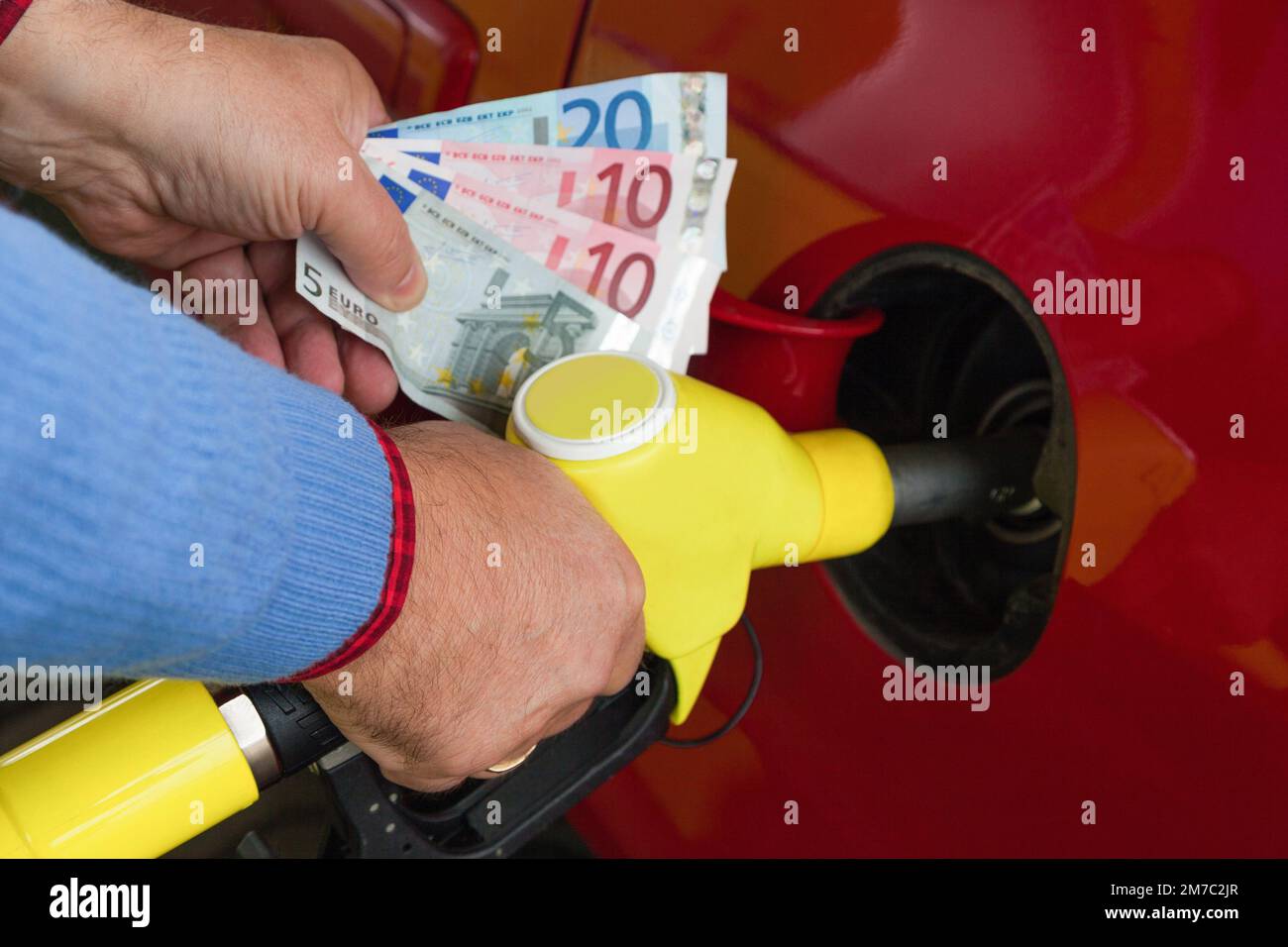 when refuelling with euro notes in hand Stock Photo