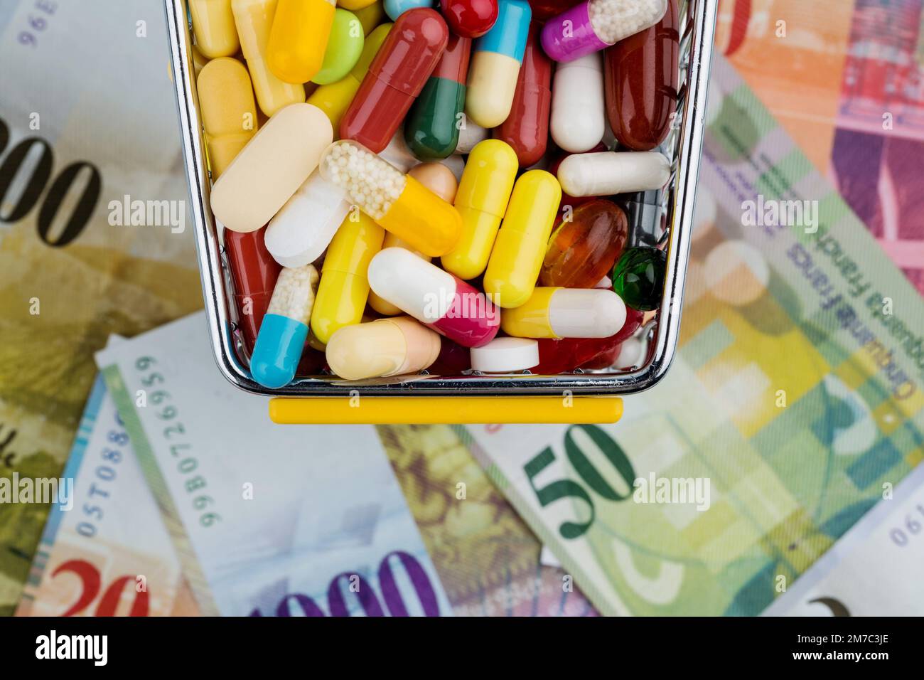 colourful pills in a trolley with Swiss Francs Stock Photo