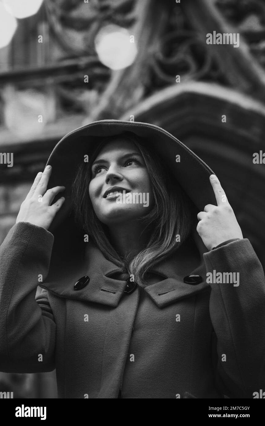 Close up pretty woman in hood on street monochrome portrait picture Stock Photo