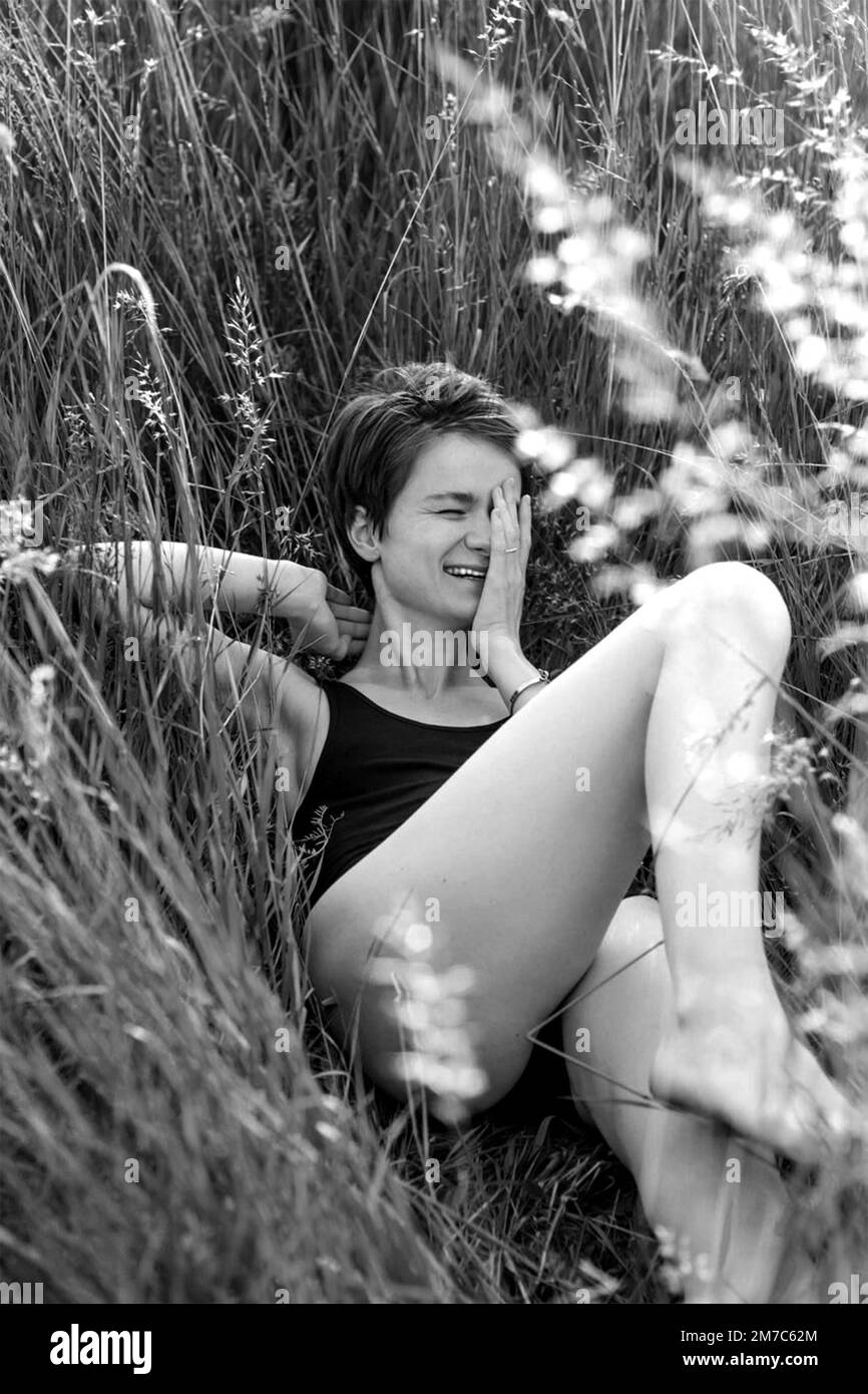 Laughing woman lying on grass monochrome scenic photography Stock Photo