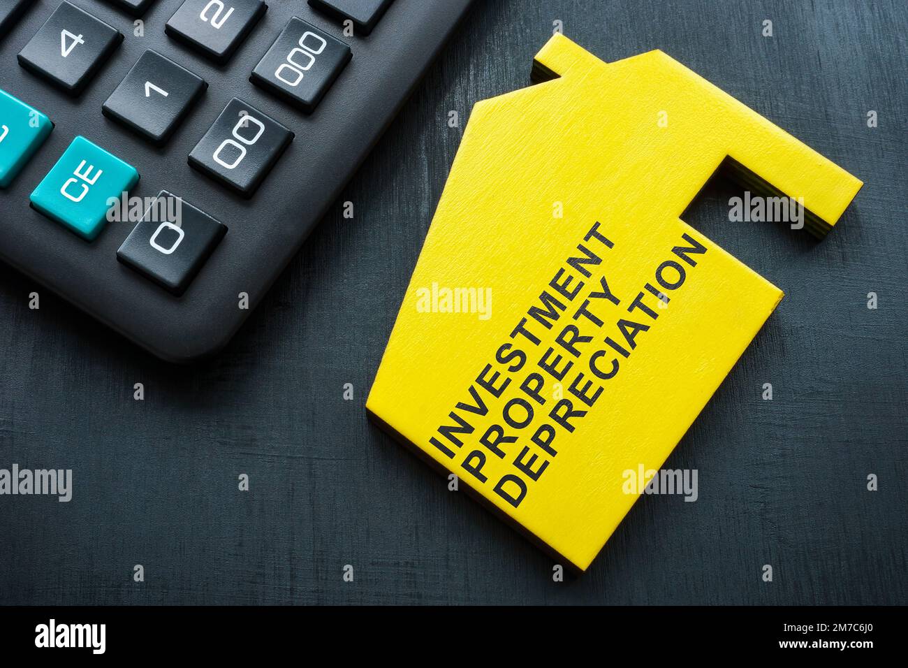 Model of house with sign investment property depreciation. Stock Photo